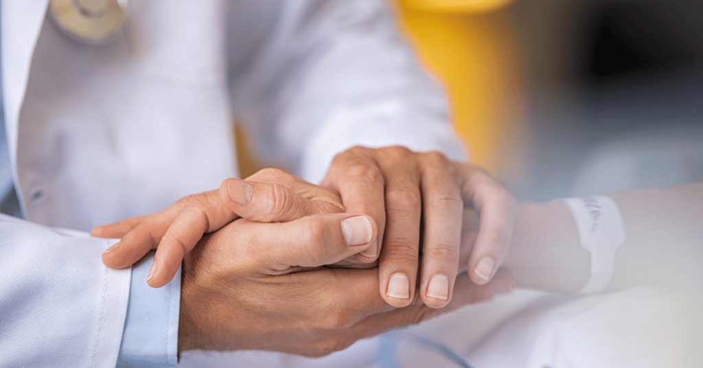 Doctor holding hands with elderly patient